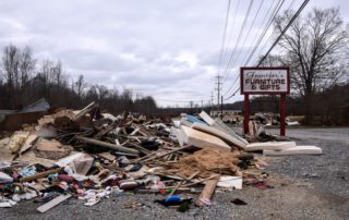 Wreckage from the August flood in Waverly sits in a pile outside a furniture shop on Highway 70.