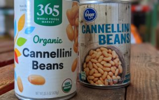 An organic can of cannellini beans and a non-organic can of cannellini beans