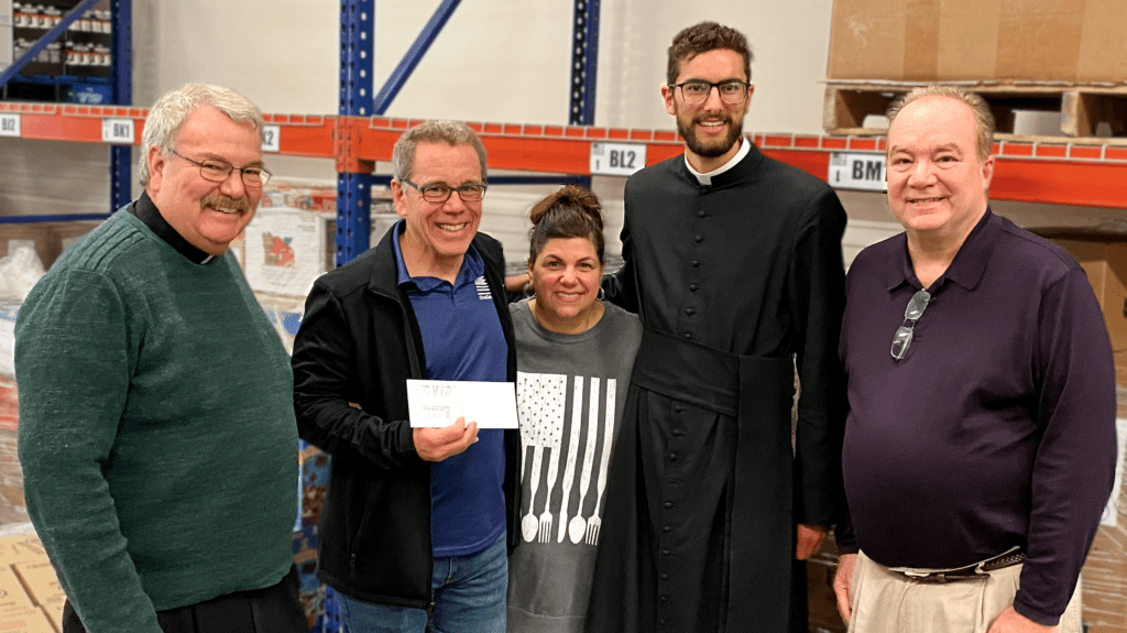 Leaders from St. Philip Catholic Church give a $20,000 check to Chris and Elaine Whitney of OneGenAway