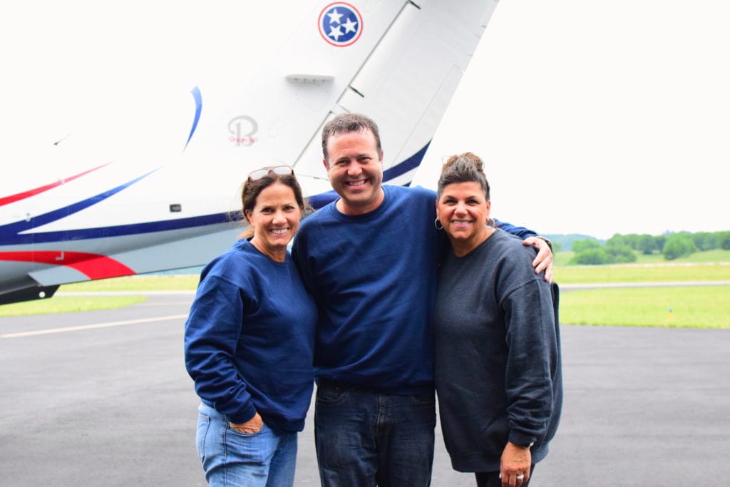 Maria Lee, Scott Lucas, and Elaine Whitney stand in front of a Tennessee state plane